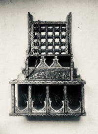 a black and white photo of a wooden shelf hanging on a wall